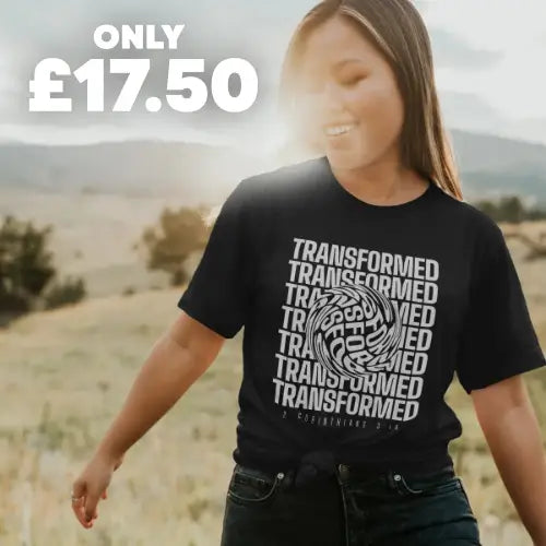 a smiling woman wearing a Christian T-shirt in a field