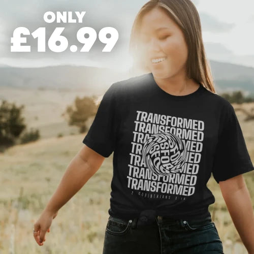 a smiling woman wearing a Christian T-shirt in a field