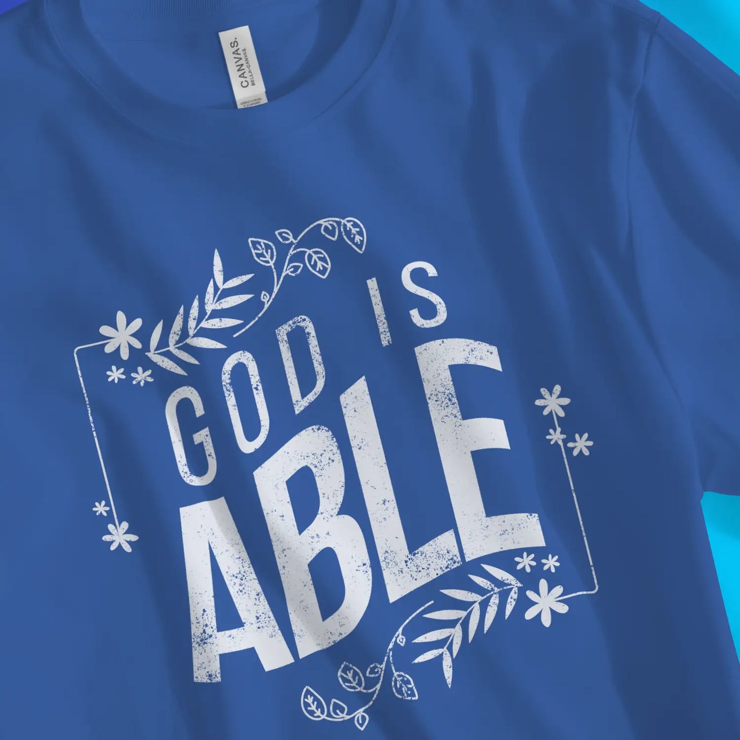 God Is Able (Floral) | Premium Unisex Christian T-Shirt, laid flat, designed by 3rd Day Christian Clothing UK